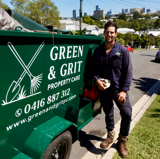 Green and Grit team member beside the branded trailer