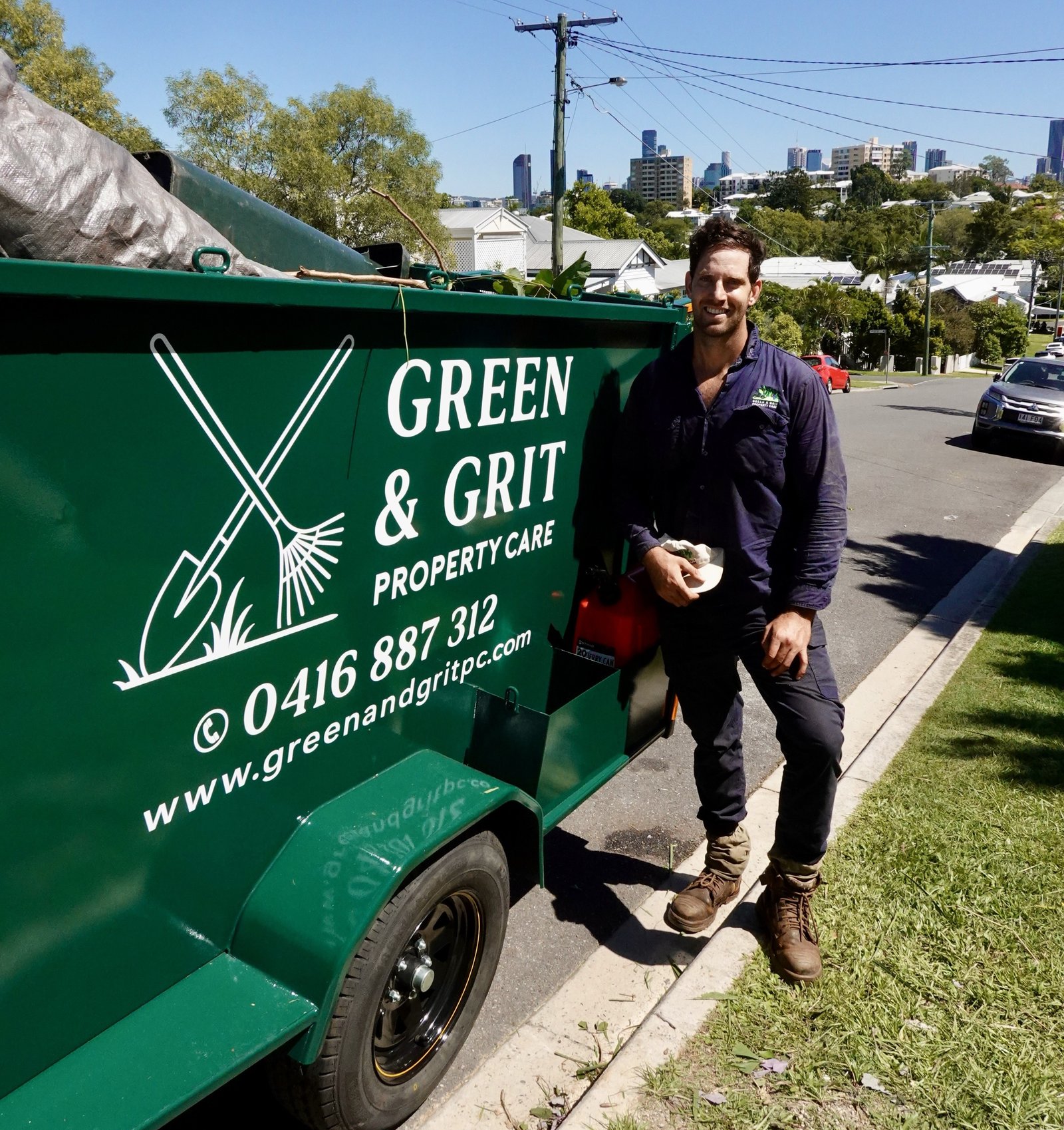 Green & Grit team member beside the branded work trailer